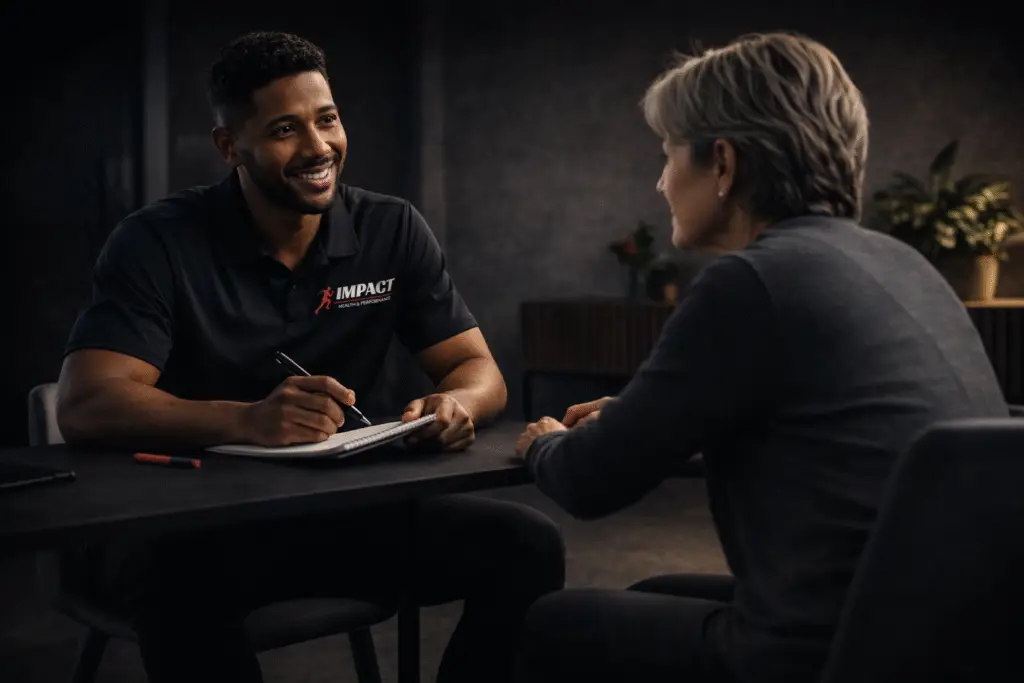 Fysiotherapeut die praat met patient aan tafel met notitieblok